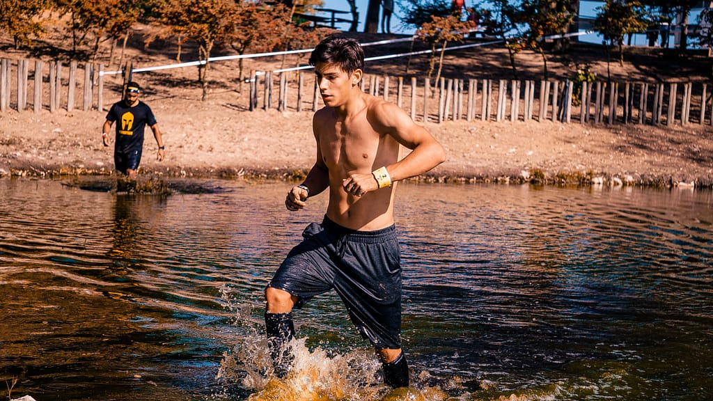 Course d'obstacle.
un jeune homme court dans l'eau